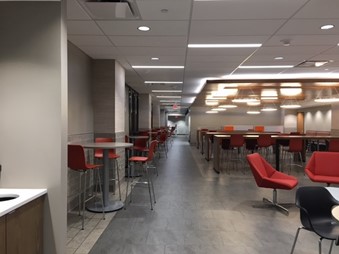 The dining area outside of the Bookmarket Eatery. There are tables and chairs on either side and a path down the center.